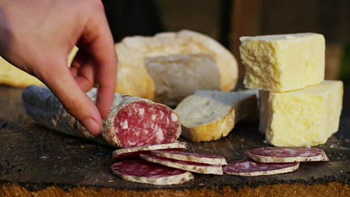 一位经验丰富的厨师在专业厨房切调味的.Il意大利萨拉米香肠是用专业的刀切非常薄的切片。