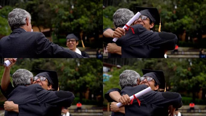 年轻的男学生在大学获得学位后拥抱父亲非常高兴