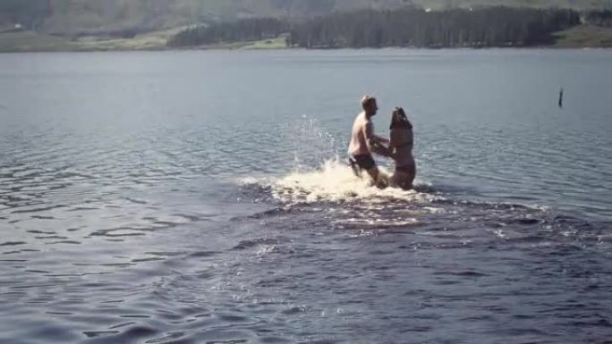 公路旅行中的夫妇在水里玩耍注意安全