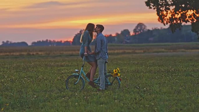 DS深情情侣在日落时骑自行车接吻