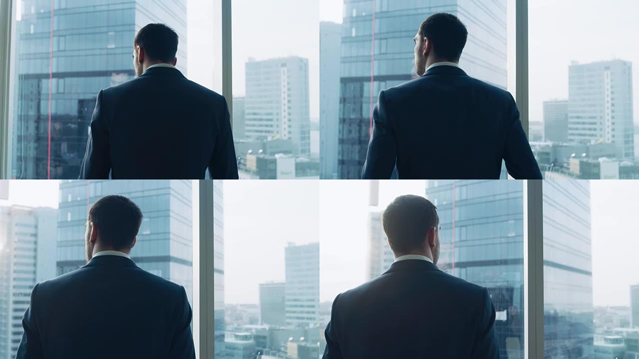 中等镜头的成功商人穿着西装站在他的办公室，考虑下一笔大生意，看着窗外。大城市商业区全景窗口视图。