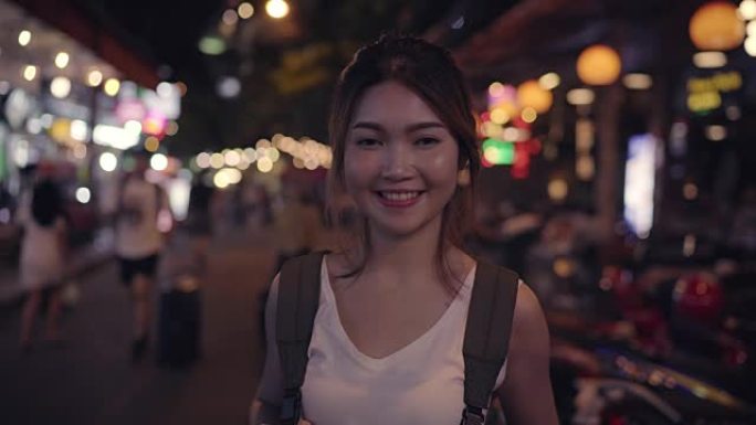旅行者背包客亚洲妇女在泰国曼谷考山路旅行。快乐的年轻女性在神奇的地标上度过假期，享受夜晚传统城市的旅