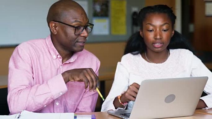 高中导师为使用笔记本电脑的女学生提供一对一的课桌学费