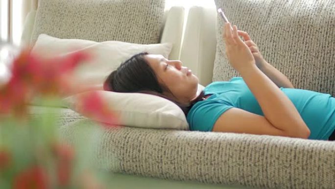 女人在放松的时候在客厅使用手机