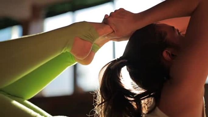 一位美丽的女教练在瑜伽工作室的垫子上做体式