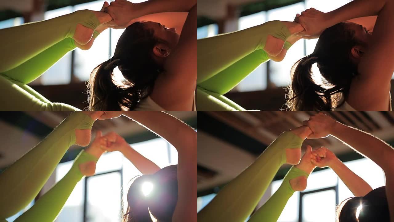 一位美丽的女教练在瑜伽工作室的垫子上做体式