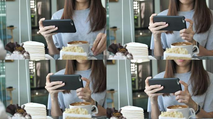 使用智能手机的亚洲女性拍摄照片蛋糕
