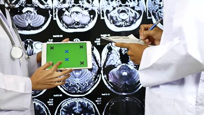医生在数字平板电脑上向另一位医生解释绿屏，绿屏