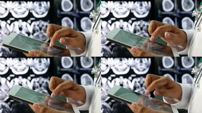 手医使用平板电脑与背景上的大脑计算机断层扫描的x射线图像