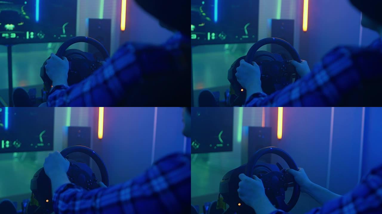 后视图镜头的职业玩家坐在赛车座椅模拟器驾驶舱与方向盘和玩赛车在线视频游戏。大电视和背景为霓虹灯的房间
