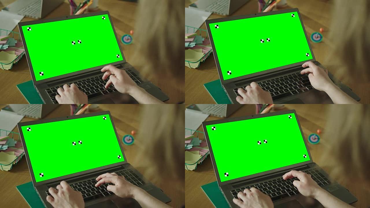 在笔记本电脑上工作的女人。特写。绿屏