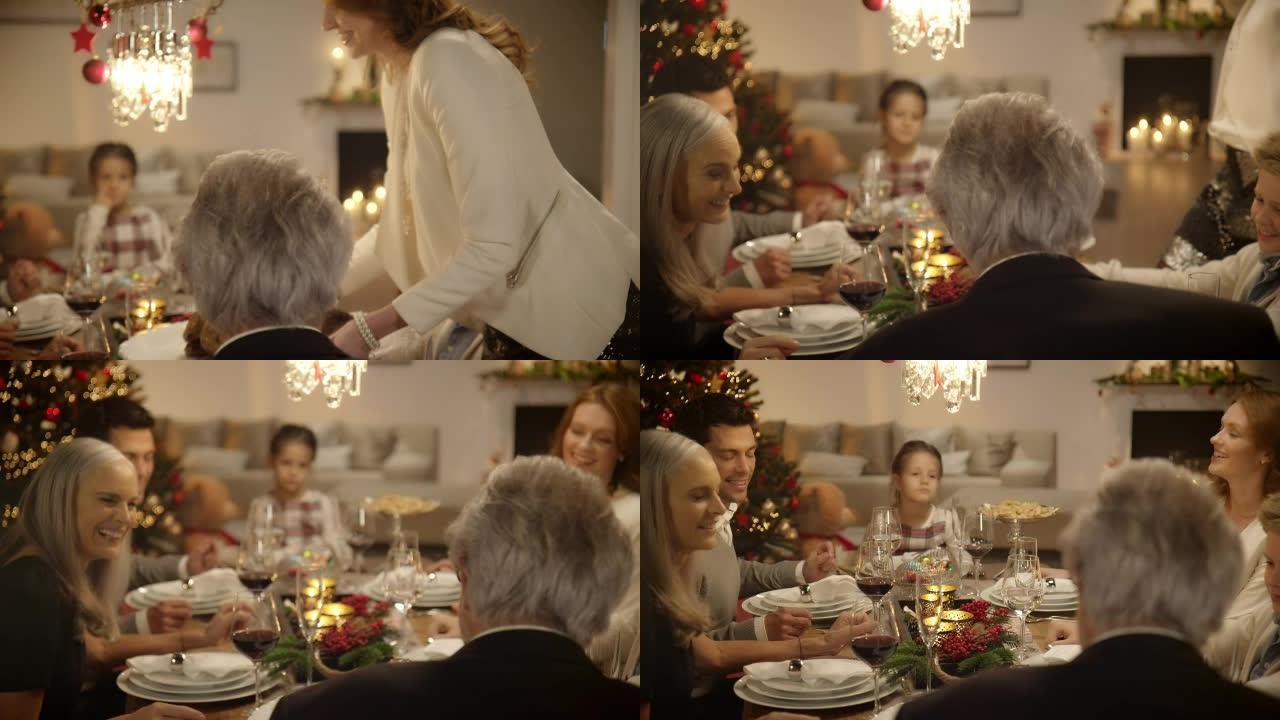 母亲坐在圣诞餐桌上给家人带来晚餐