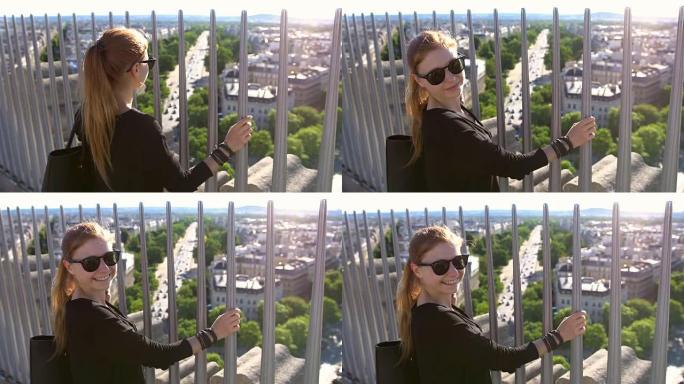巴黎凯旋门顶上的游客俯瞰着这座城市，对着镜头微笑