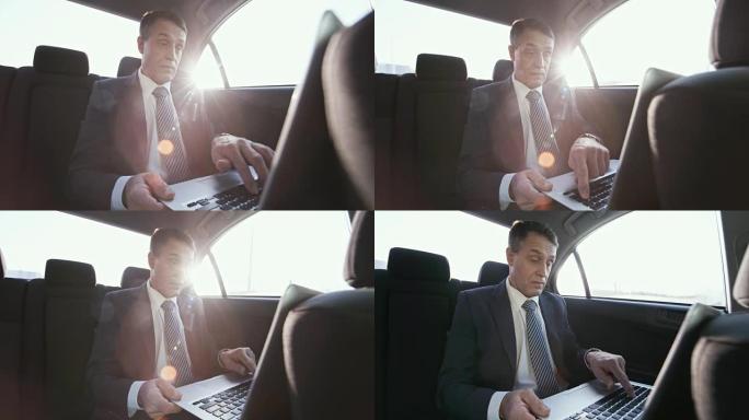 商人在出租车上使用笔记本电脑