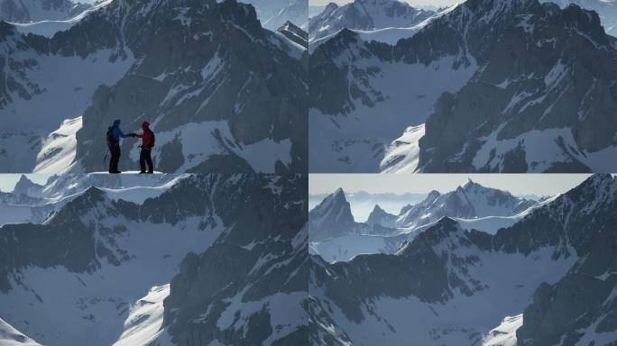 登山者在白雪覆盖的山峰上握手
