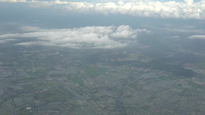4k剪辑镜头，从飞机的窗户向外看，可以看到河旁的稻田和天空上的云，运输概念