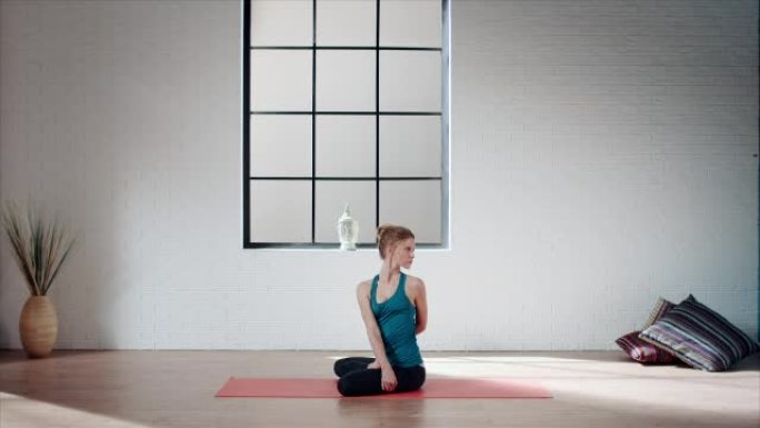 女人在健身房练习瑜伽 (莲花中的脊椎扭转)