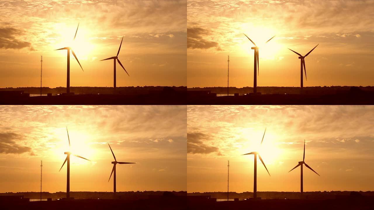 两个风力涡轮机在日出时转动
