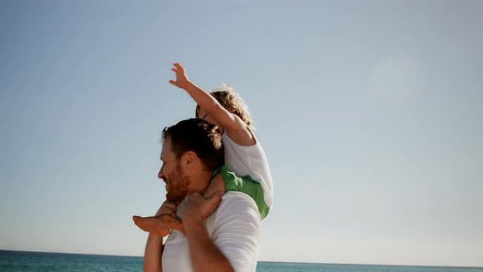 海滩上的家人父子亲情互动儿子坐在爸爸箭头