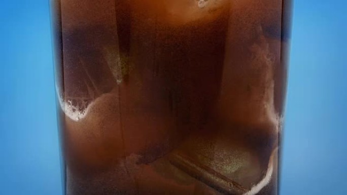 可乐饮料倒在玻璃上的冰块上