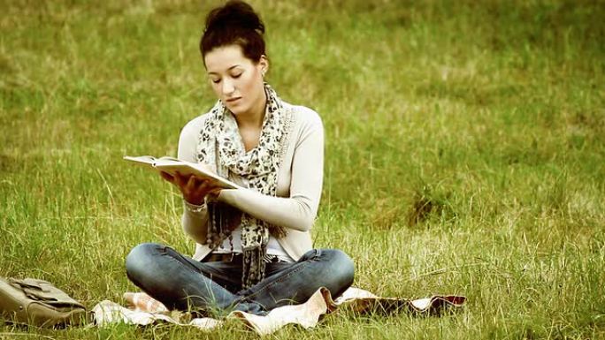 年轻的女学生在外面阅读和学习。