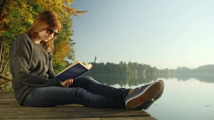年轻女子在湖边看书