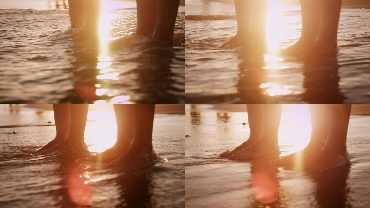 海滩上的情侣沙滩上两双脚金色水面阳光水面