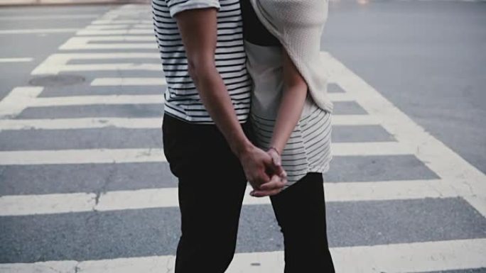 慢动作快乐的年轻西班牙裔男子在纽约繁忙的街道交叉口附近与欧洲女友拥抱跳舞