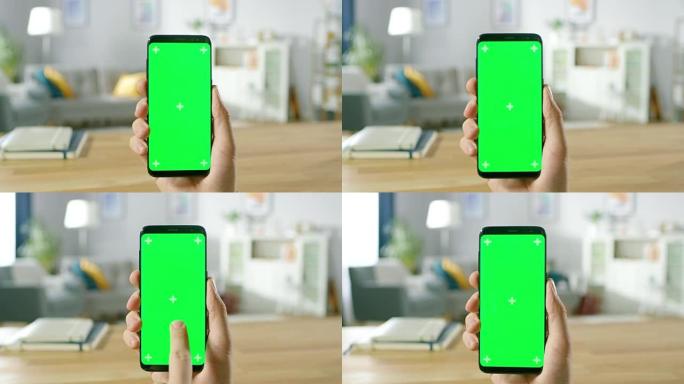 一个男人在现代绿色模拟屏幕智能手机上握着手势的特写镜头。用手指触摸手机色度键屏幕。