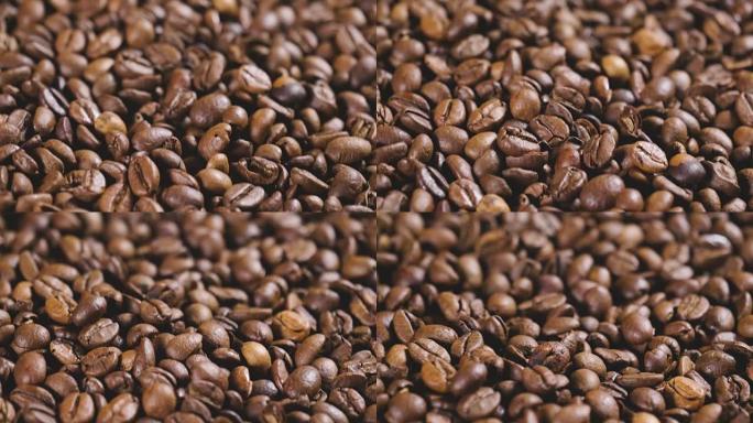一只手触摸一把咖啡豆的特写镜头，以闻到气味和一致性。优质咖啡仍然热气腾腾。