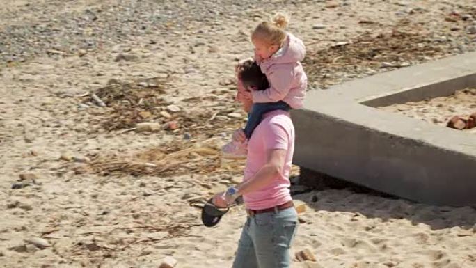 女儿在海滩上的父亲肩膀上