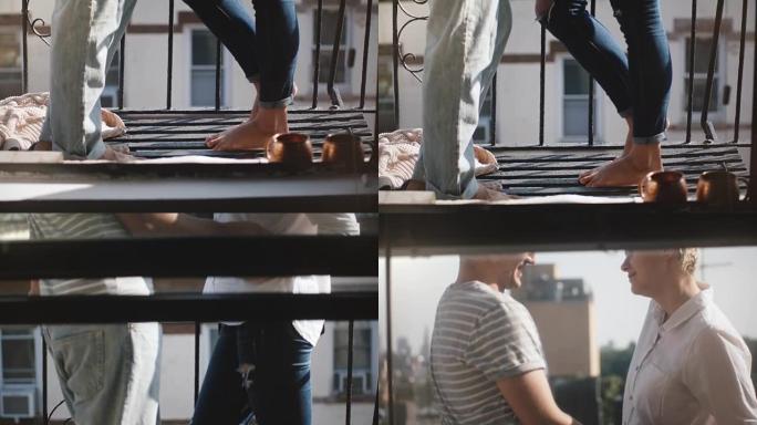 相机向上倾斜，露出快乐浪漫的男人和女人赤脚站在美丽的早晨布鲁克林阳台上