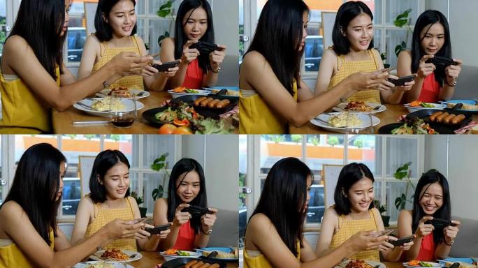 有吸引力的年轻亚洲女士在社交媒体上拍照，并在意大利美食，香肠和沙拉中享用午餐