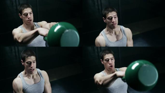 专注的男人在健身房用壶铃做运动