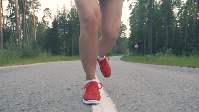 在正面视图中，女性腿沿着小巷奔跑的慢动作镜头