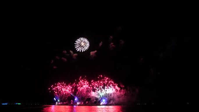 4k精彩的多色烟花镜头，夜空烟雾笼罩着海上大船的背景，庆祝概念