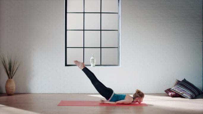 女人在健身房练习瑜伽 (蝗虫姿势)