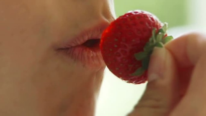 女孩吃草莓的极端特写镜头