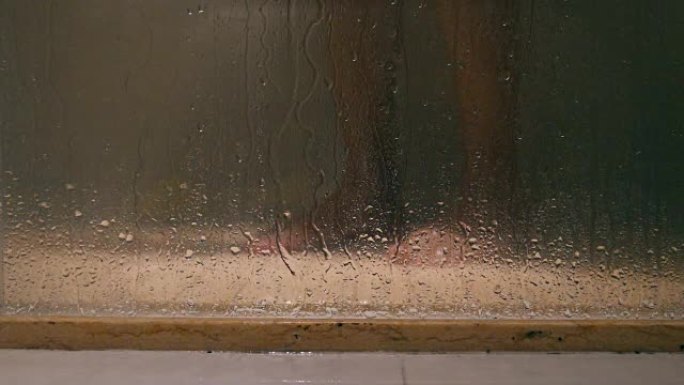 玻璃门后面洗澡的人的腿