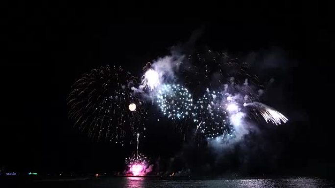 4k精彩的多色烟花镜头，夜空烟雾笼罩着海上大船的背景，庆祝概念