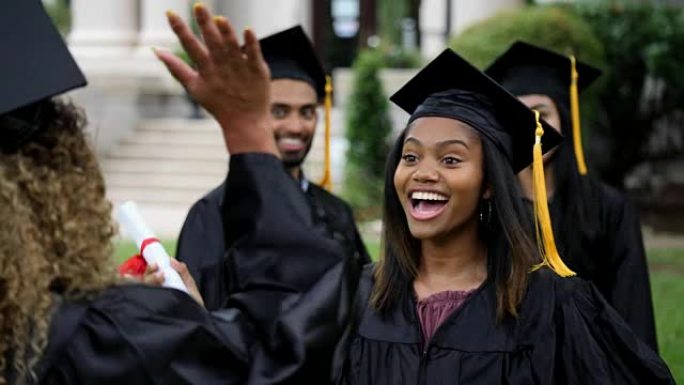 兴奋的非洲裔美国大学毕业生互相给予高五
