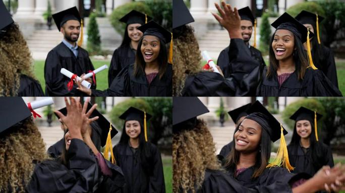 兴奋的非洲裔美国大学毕业生互相给予高五