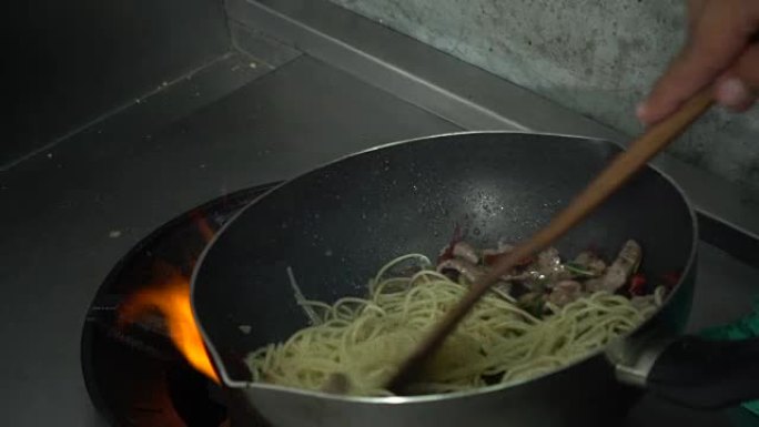 慢动作-厨师正在餐厅的厨房准备和烹饪意大利面食物。