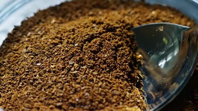 专业调酒师用合适大小的勺子挑选咖啡粉，制成高品质的浓缩咖啡。