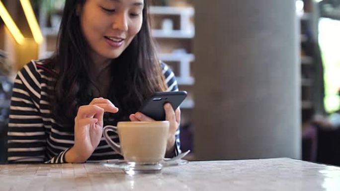 年轻女子在咖啡馆用手机付款，无内容付款