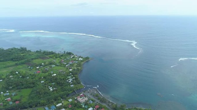 空中飞行: 在充满活力的大溪地的一个宽阔河口附近的沿海小镇上空飞行。