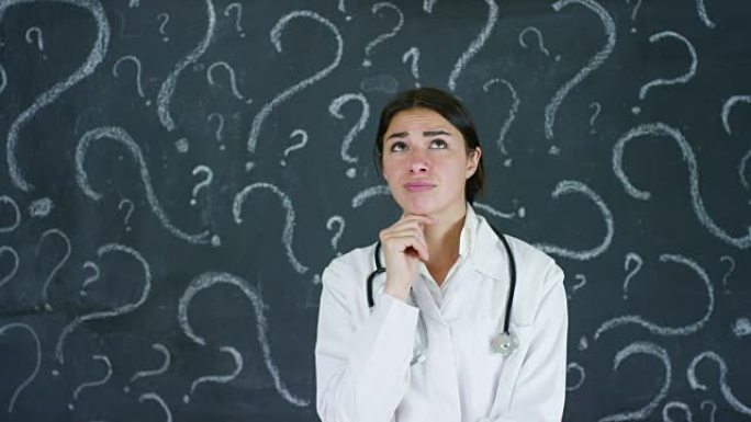 一位美丽的女医生 (学生) 在黑板上思考选择职业的肖像。