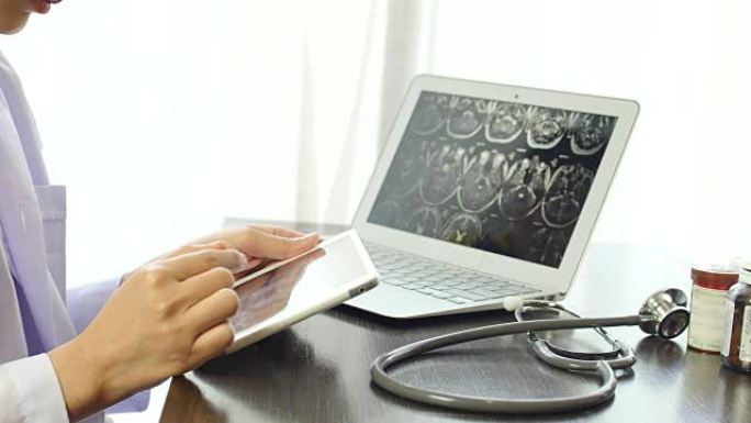 用笔记本电脑和药瓶在平板电脑上检查图像x射线MRI的女医生