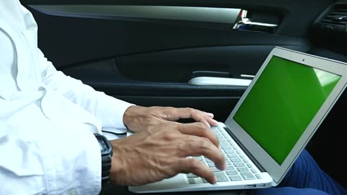 商人在汽车的后部使用绿屏笔记本电脑，4K(UHD)