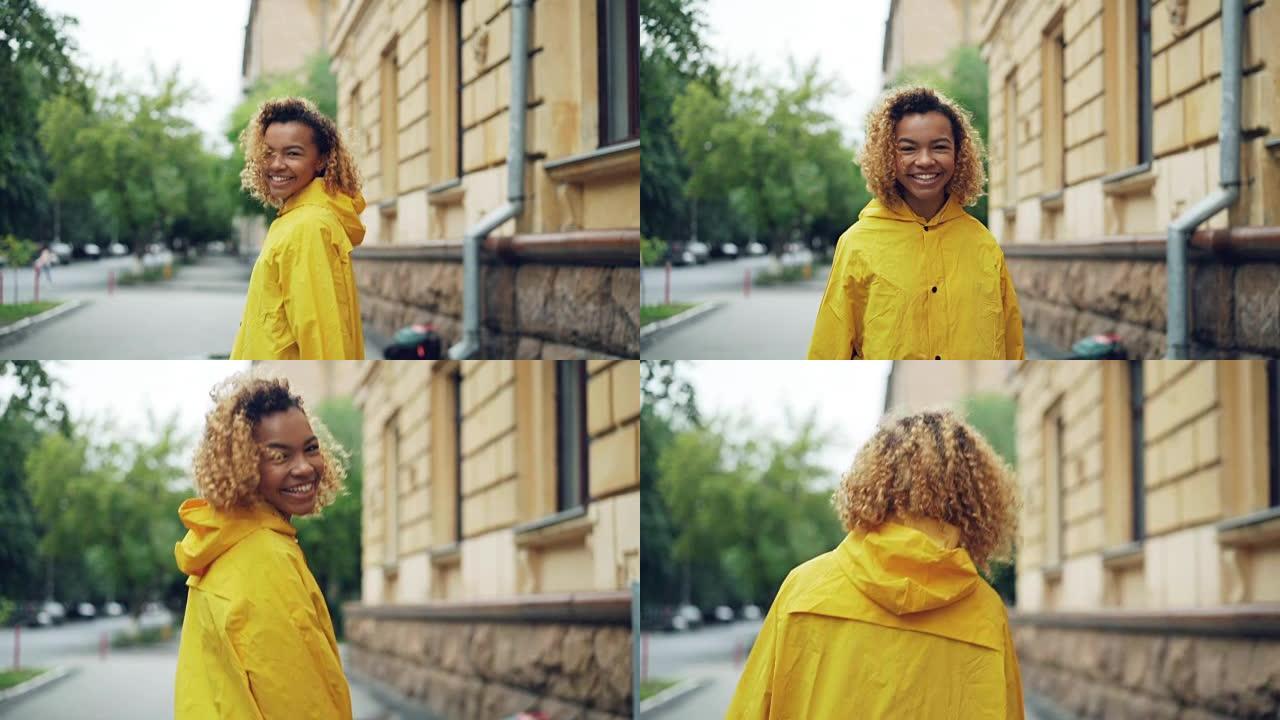 微笑的非洲裔美国妇女的慢动作肖像，穿着鲜艳的外套走在街上，转向相机，看着相机，然后转身离开。